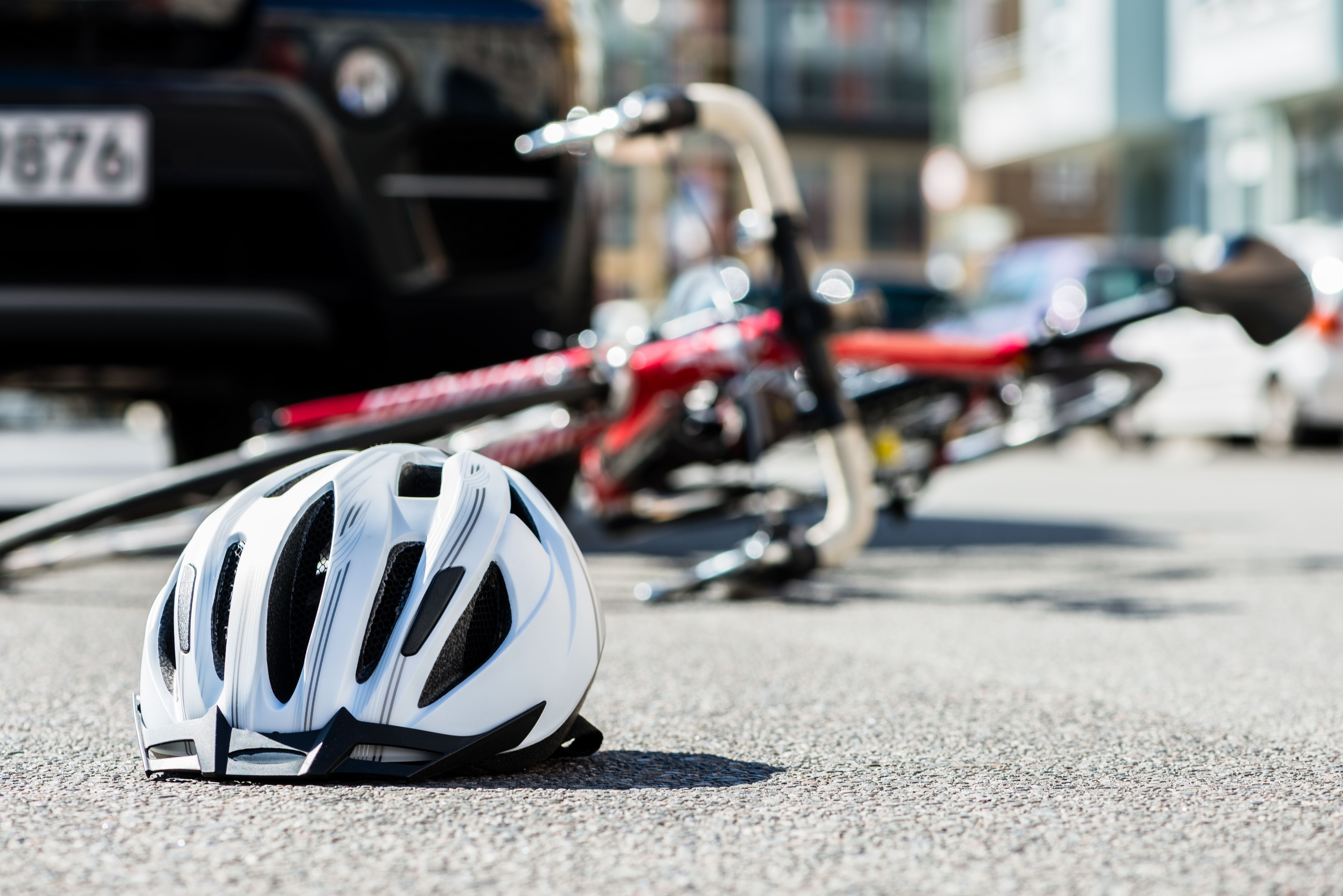 overturned bicycle on road in front of car